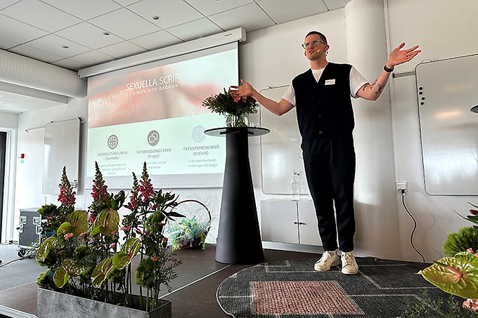 En person står och gestikulerar på en scen