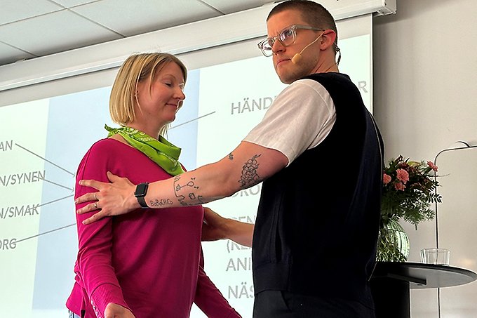 Två personer står mitt emot varandra på en scen