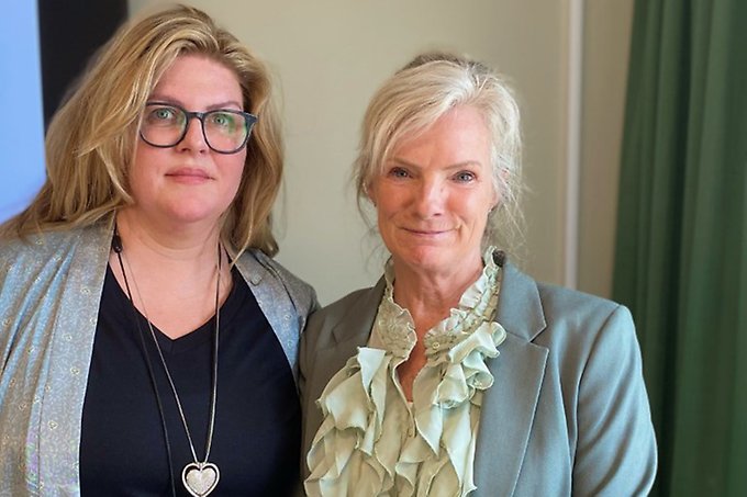 Två personer står tätt ihop vid en pulpet