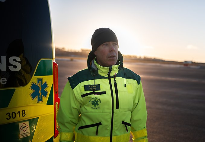Porträttbild på narkosläkaren Joakim som står bredvid en ambulans på Östersunds flygplats.