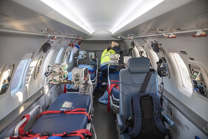 Insidan på ett ambulansflygplan, med tomma stolar och liggbäddar för patienter.